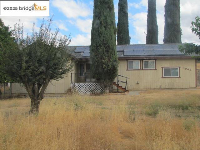1943 South Ranchero Road Valley Springs, CA 95252 - Photo 5 of 23 Rear view of property featuring a wooden deck and roof mounted solar panels