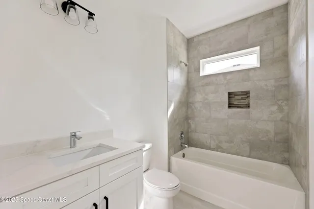 a bathroom with a granite countertop sink a toilet and bathtub