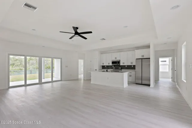 a view of an empty room with a kitchen