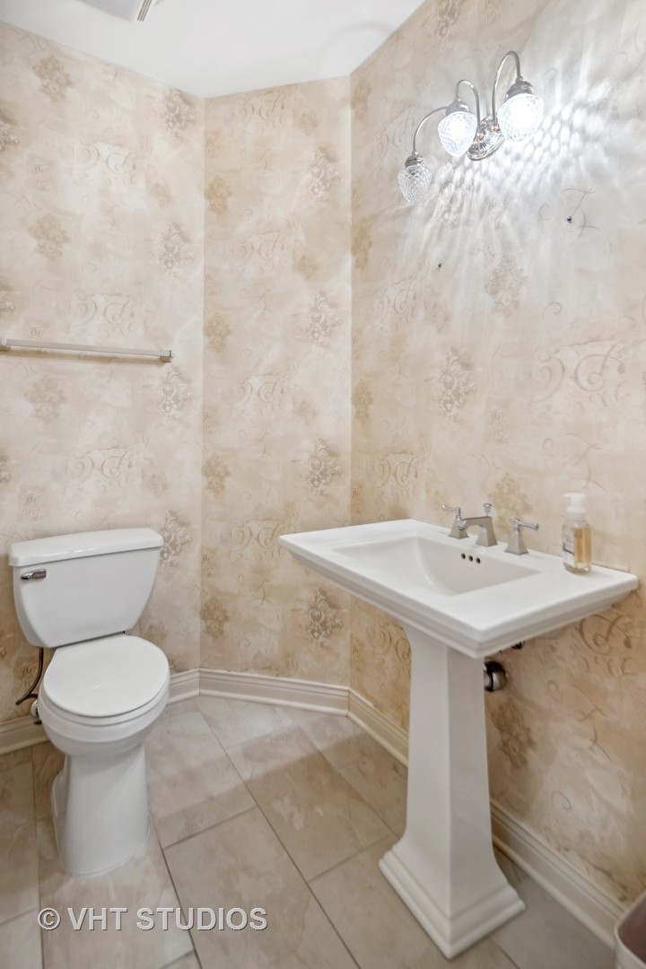 311 Pinehurst Drive Palos Heights, IL 60463 - Photo 7 of 24 a bathroom with a sink a toilet and a mirror