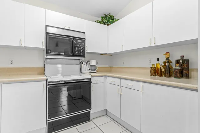 a kitchen with granite countertop a stove microwave and sink