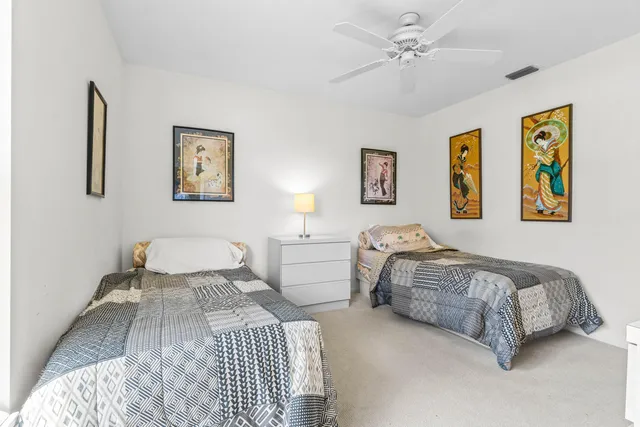 a bedroom with two beds and painting on the wall