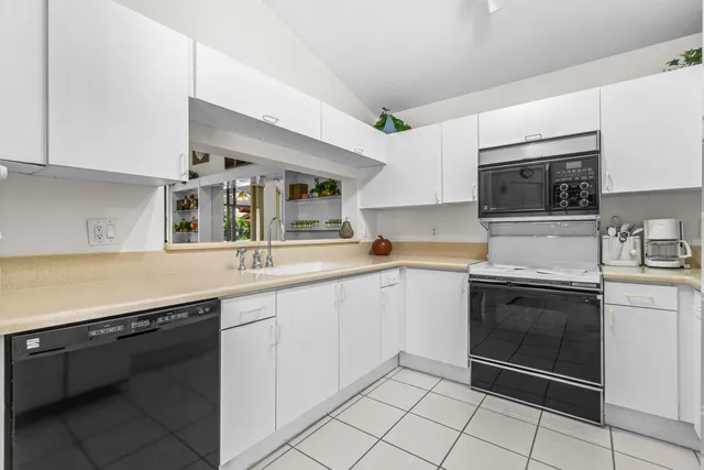 a kitchen with granite countertop a sink dishwasher stove and cabinets