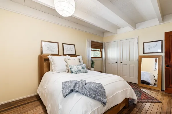 a bedroom with a bed and wooden floor
