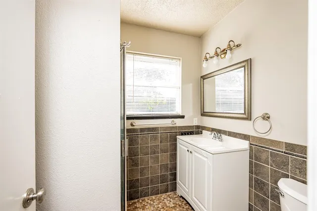 a bathroom with a sink a toilet and a window
