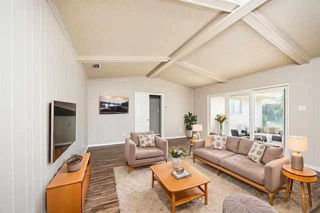a living room with furniture a flat screen tv and a large window