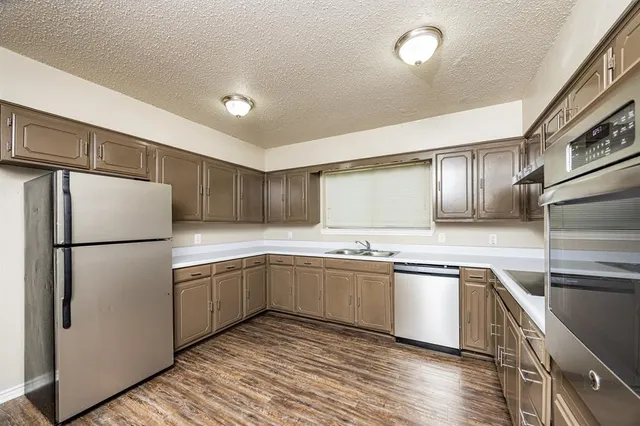 a kitchen with white cabinets sink and refrigerator