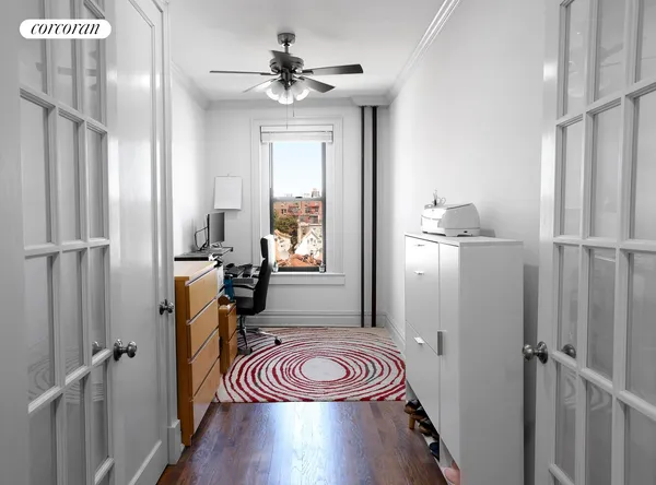 a view of empty room with wooden floor and fan