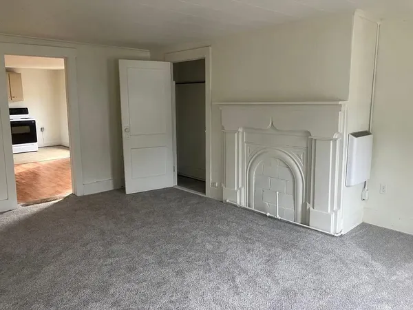 an empty room with a fireplace and windows