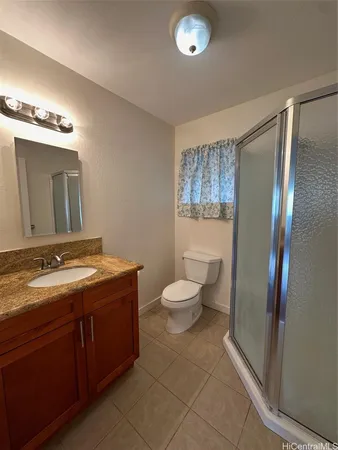 a bathroom with a granite countertop toilet sink and mirror