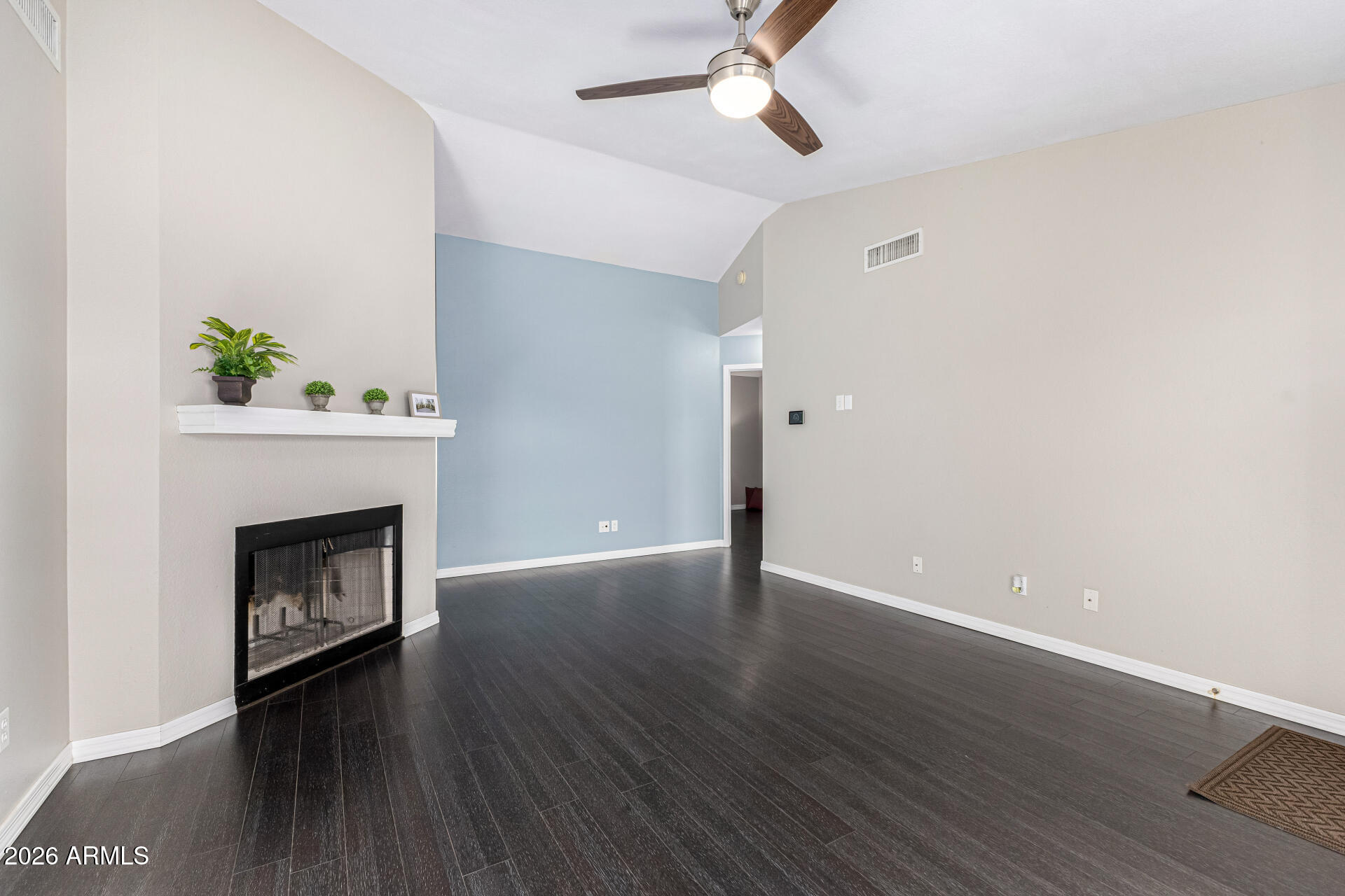 2710 East Rock Wren Road Phoenix, AZ 85048 - Photo 7 of 56 a view of an empty room with wooden floor fireplace and a window