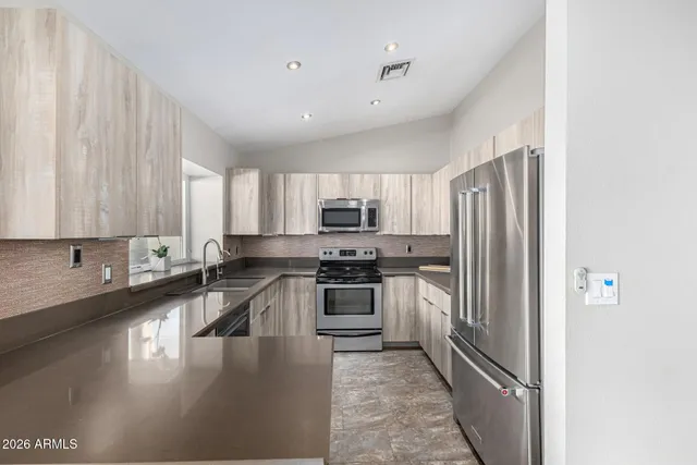 a kitchen with stainless steel appliances a refrigerator and a stove top oven