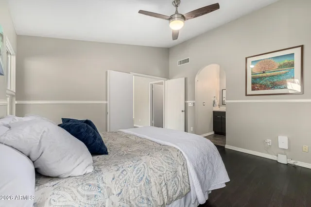 a spacious bedroom with a bed and a chandelier
