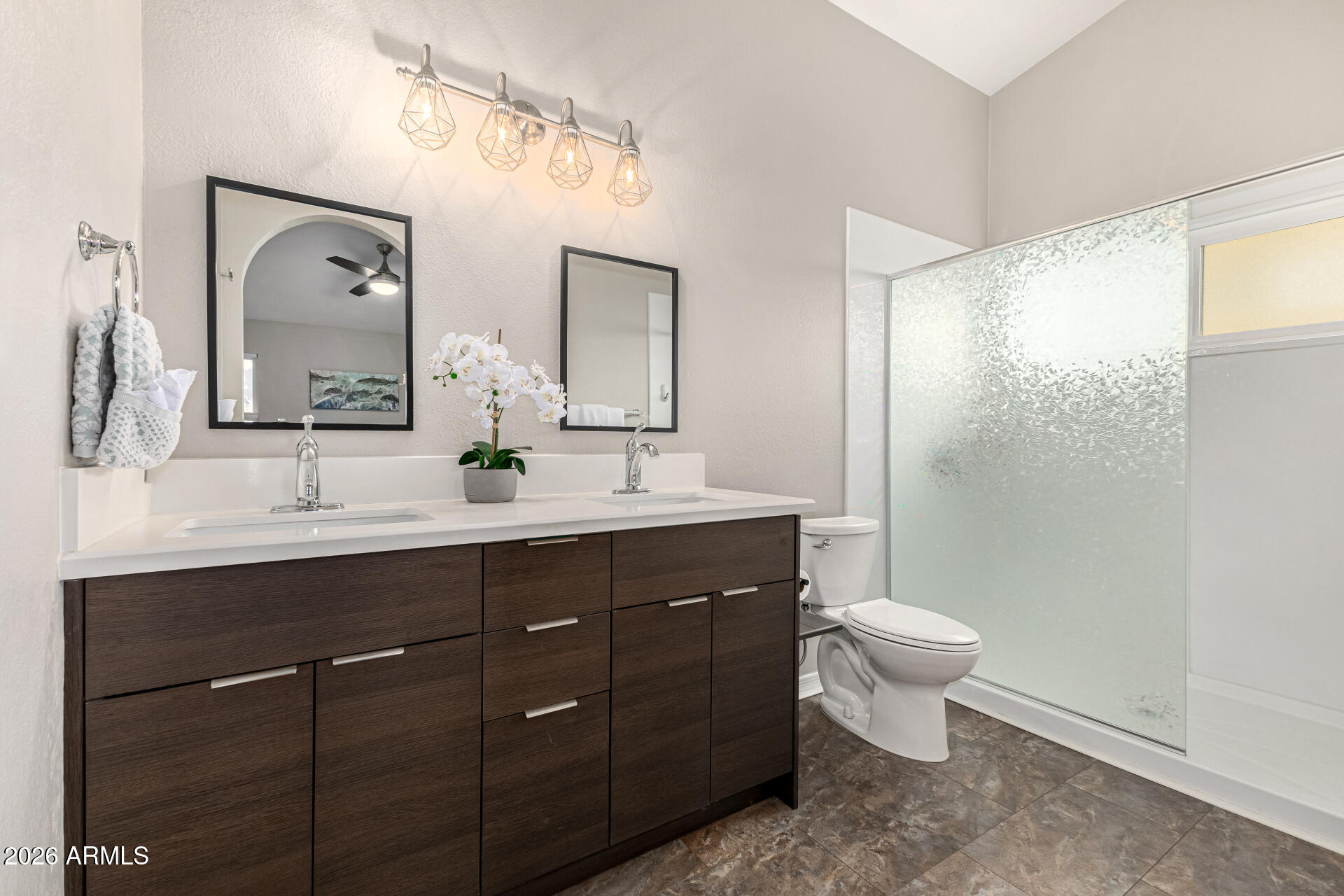 2710 East Rock Wren Road Phoenix, AZ 85048 - Photo 19 of 56 a bathroom with a toilet a sink a mirror and a shower