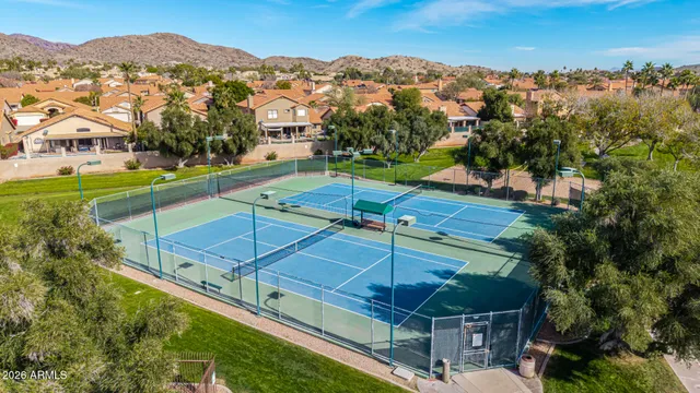 an aerial view of residential houses with outdoor space and trees