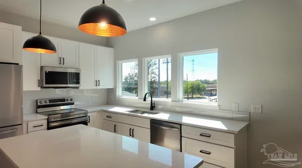 a kitchen with stainless steel appliances granite countertop a sink a stove and a microwave