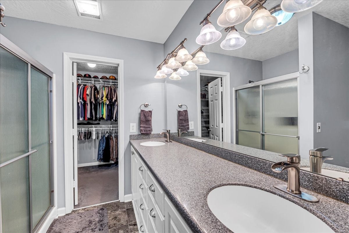 3955 River Road Baxter, TN 38544 - Photo 30 of 78 a bathroom with a granite countertop sink a large mirror and a shower