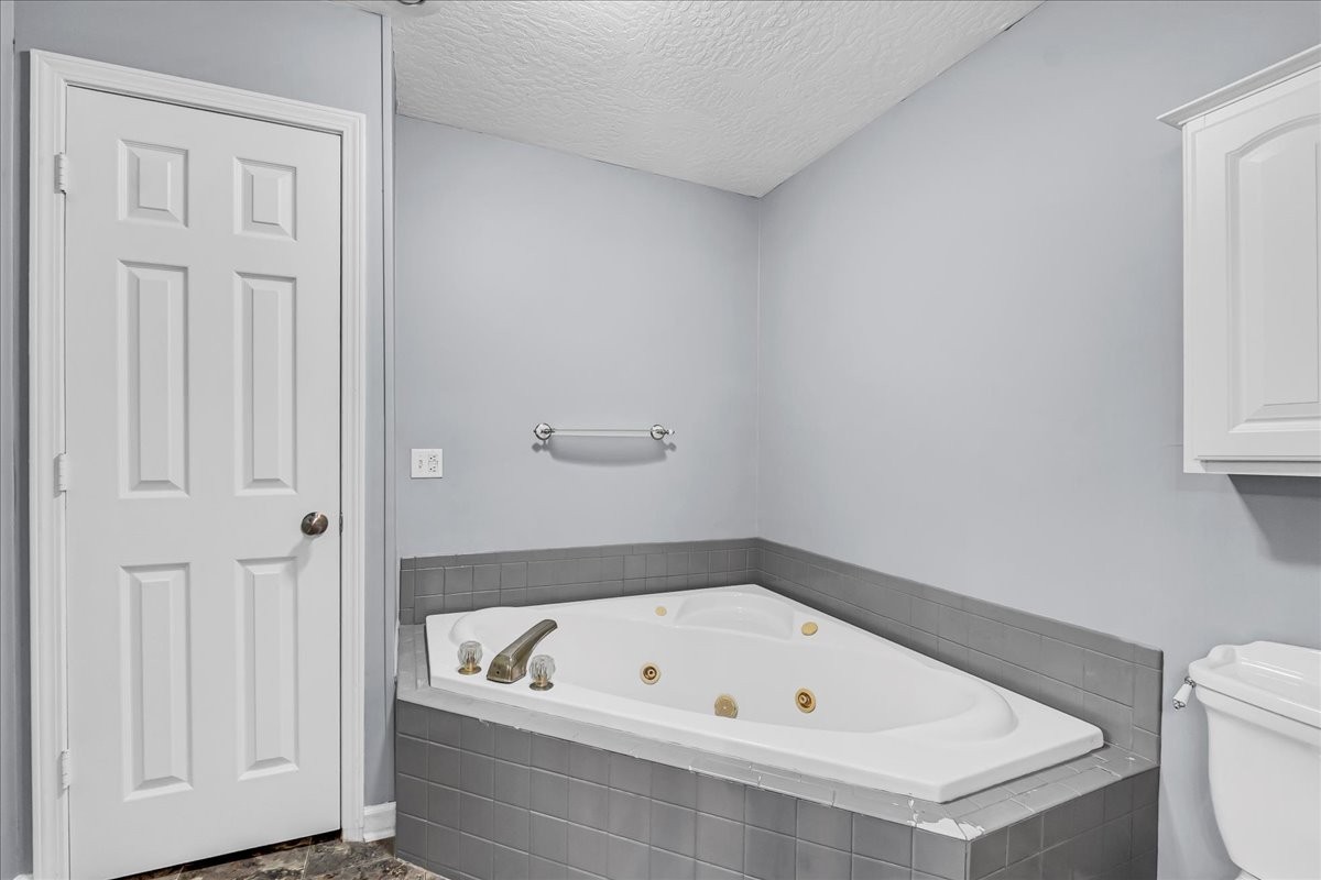 3955 River Road Baxter, TN 38544 - Photo 32 of 78 a bathroom with a tub a toilet and a window
