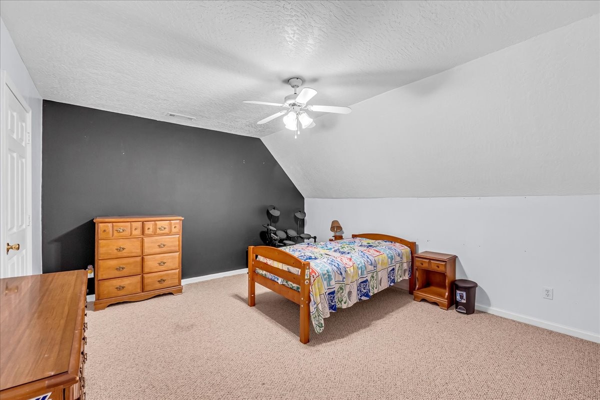 3955 River Road Baxter, TN 38544 - Photo 37 of 78 a bedroom with a bed and a chandelier