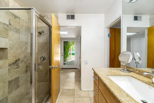 a bathroom with a granite countertop sink and a mirror