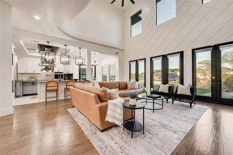 a living room with lots of furniture wooden floor and a large window