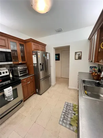 a kitchen with stainless steel appliances granite countertop a refrigerator and a stove top oven