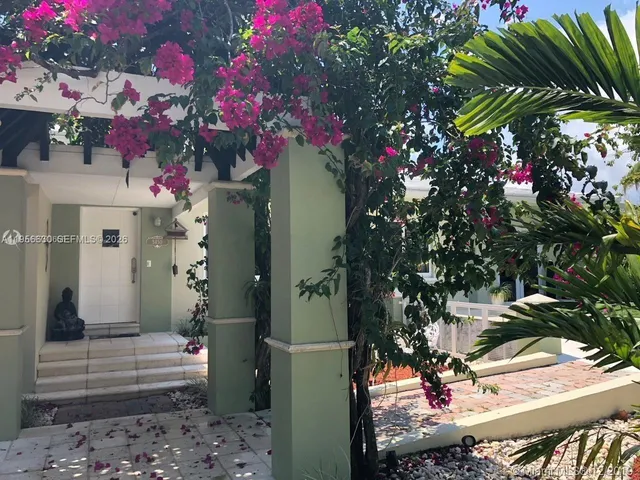 a front view of a house with a tree