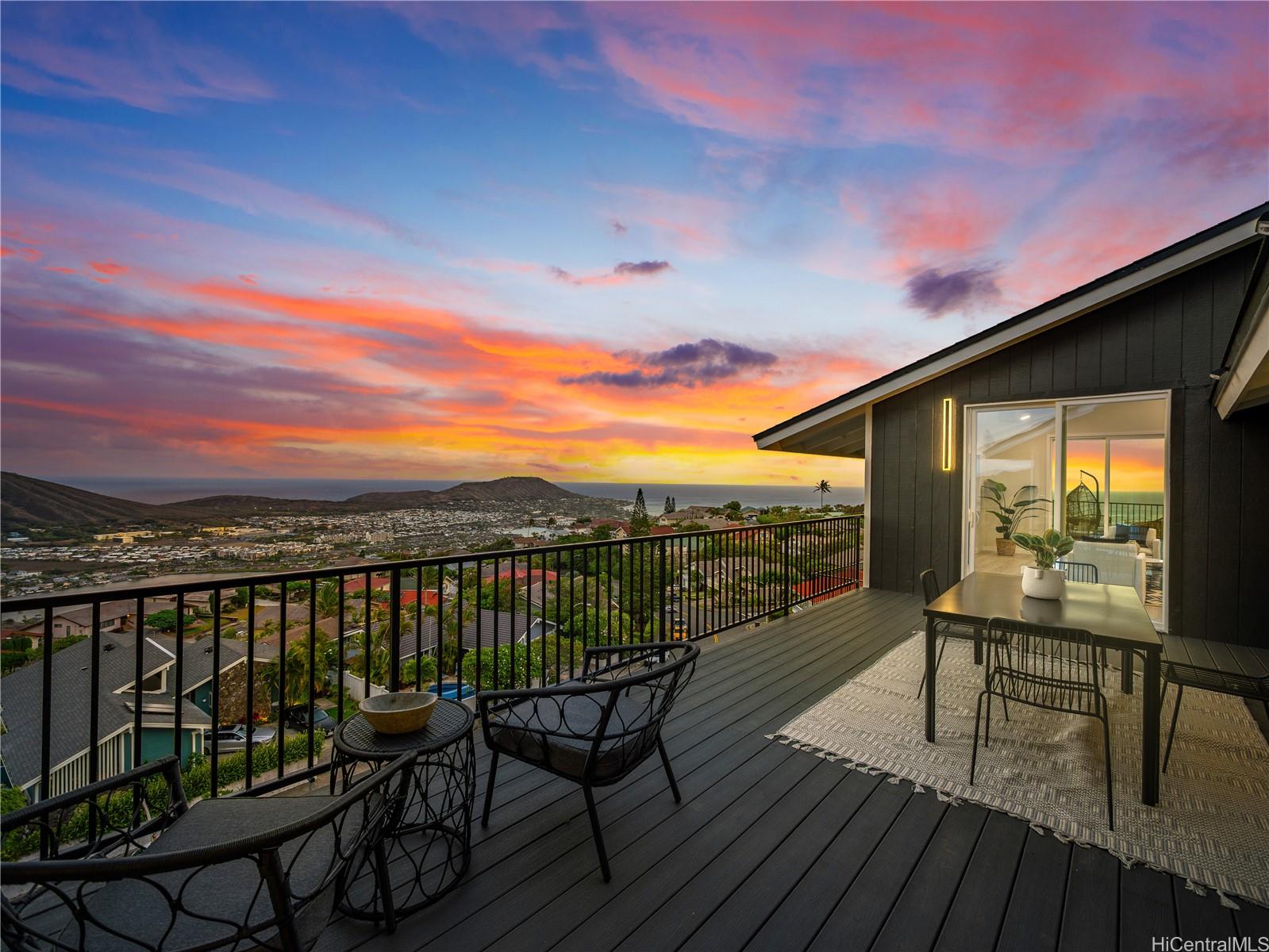 a view of a balcony with wooden floor and outdoor seating