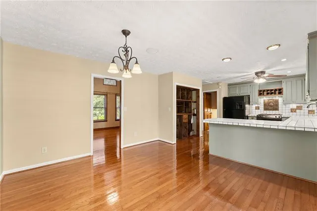 a view of a kitchen with wooden floor and a window