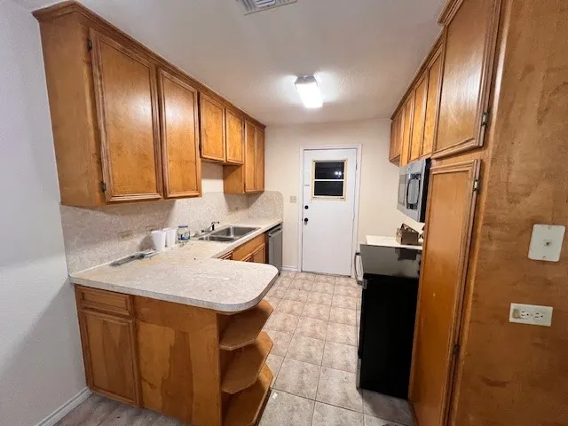 a kitchen with a sink a refrigerator a stove a microwave and island