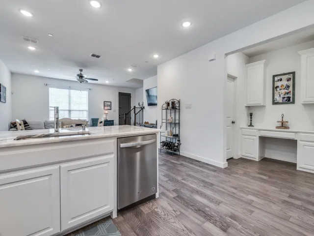 a room with kitchen island a sink and a stove with wooden floor