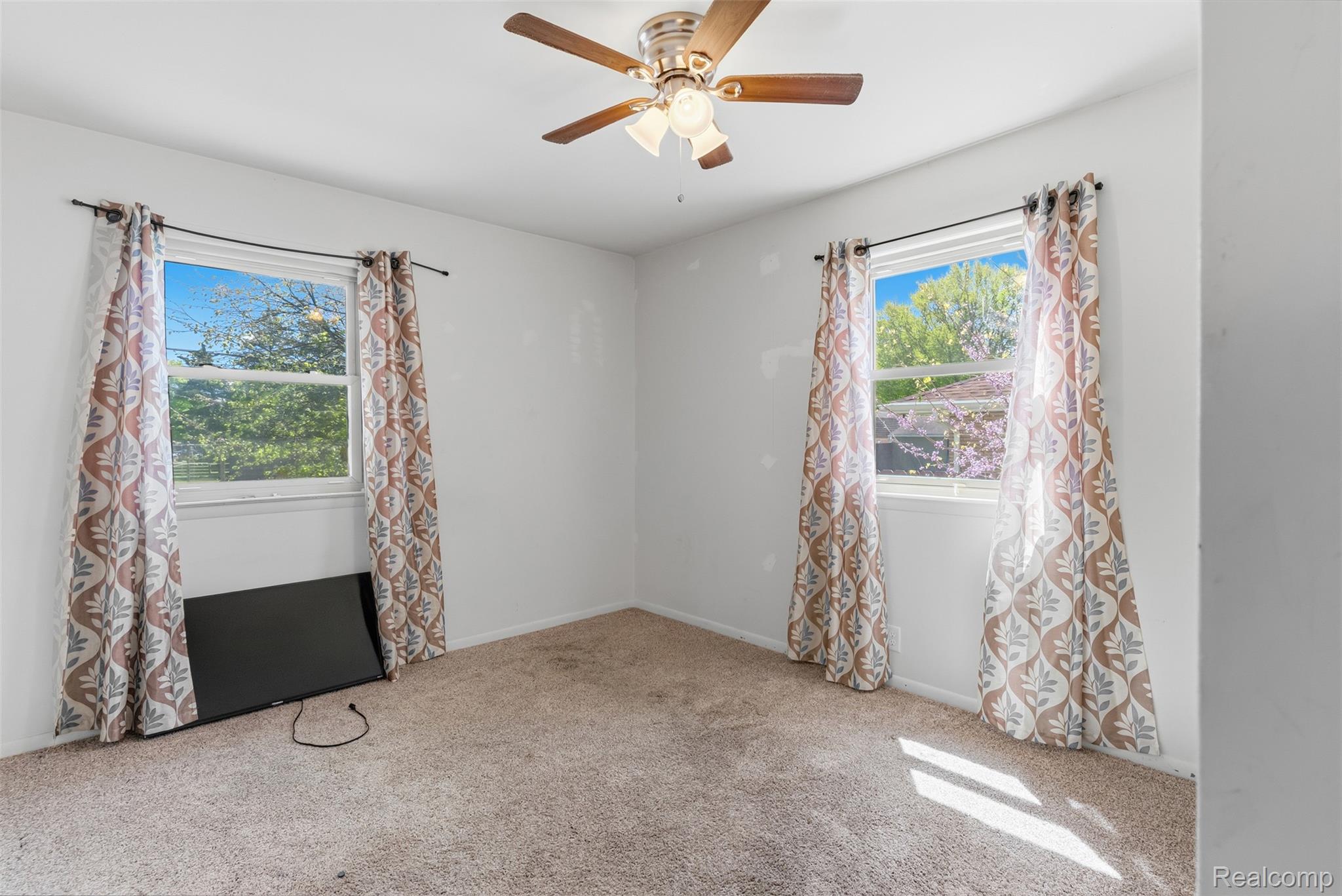 7230 North Center Road Mount Morris, MI 48458 - Photo 16 of 33 Spare room featuring light colored carpet and a ceiling fan