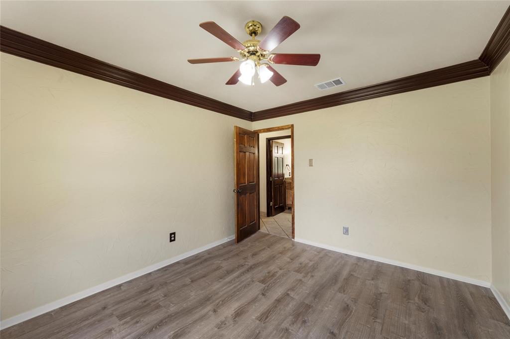 3433 West Tours Road West, TX 76691 - Photo 27 of 40 Unfurnished room with ornamental molding, wood finished floors, and a ceiling fan