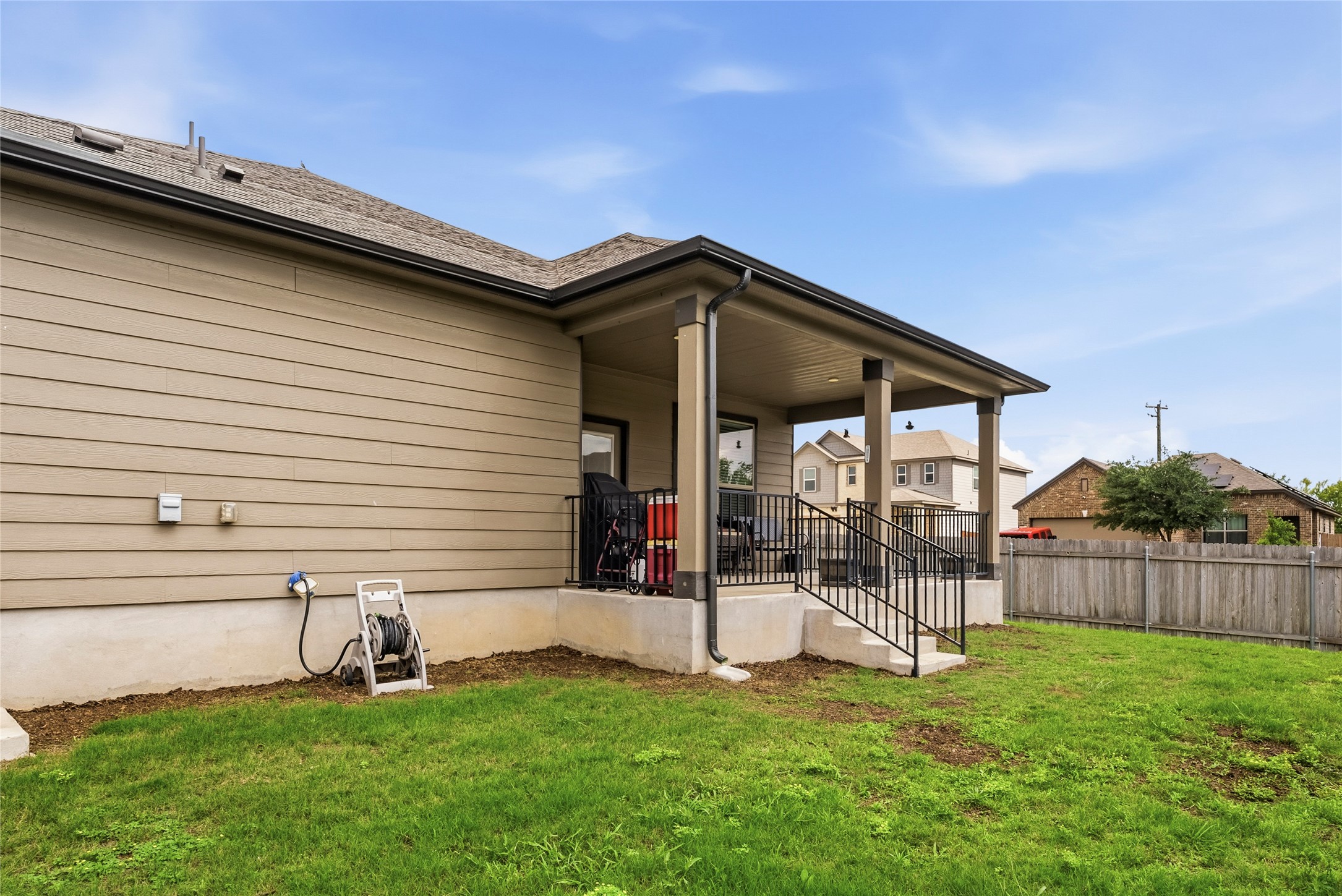 105 West Point Way Elgin, TX 78621 - Photo 16 of 27 Covered patio with multiple columns and black metal railings, overlooking a grassy area