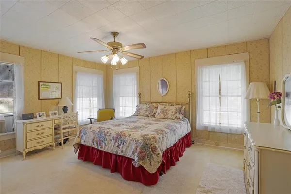 a bedroom with a bed dresser and a window