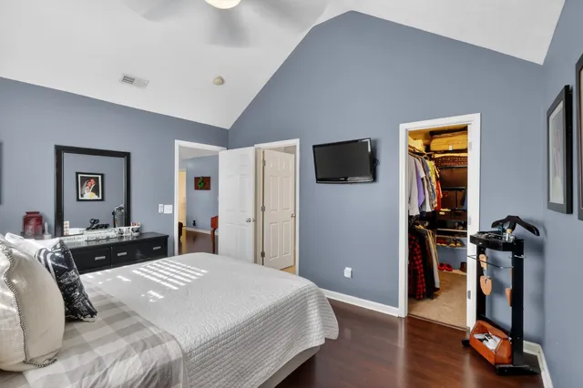 a bedroom with a bed and wooden floor