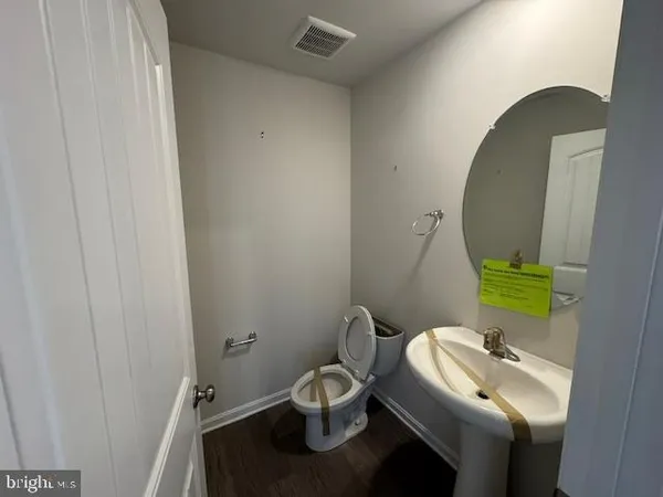 a kitchen with granite countertop a refrigerator and wooden floors