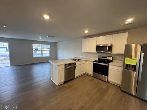 a kitchen with granite countertop a refrigerator and a stove top oven