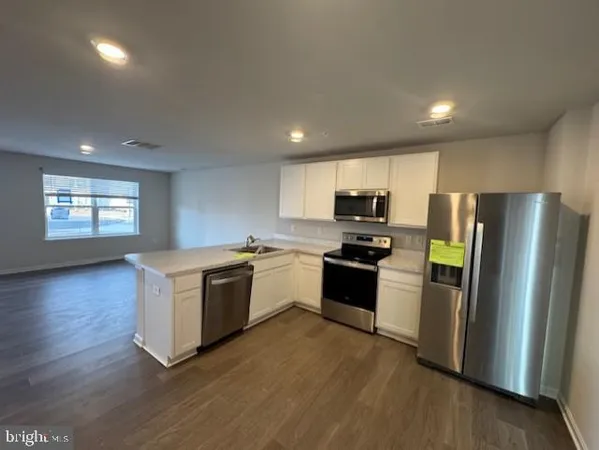 a kitchen with kitchen island a sink appliances and cabinets