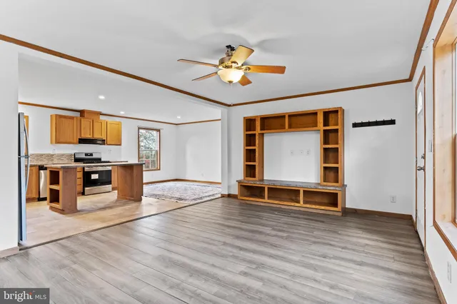 a view of kitchen with stainless steel appliances wooden floor and window