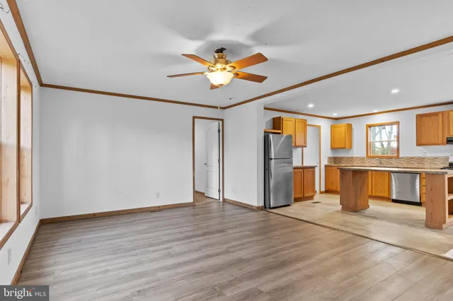 a view of an empty room with window and wooden floor