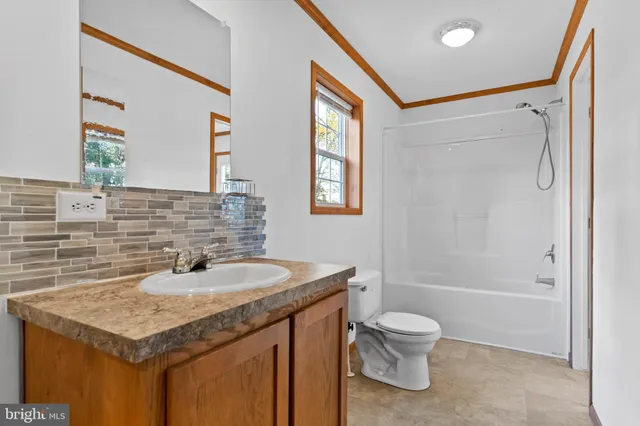 a bathroom with a granite countertop sink toilet a shower and a mirror