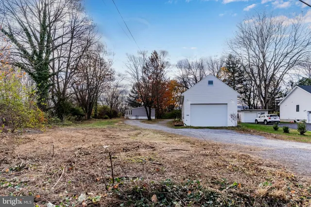 a view of a house with a yard and large tree