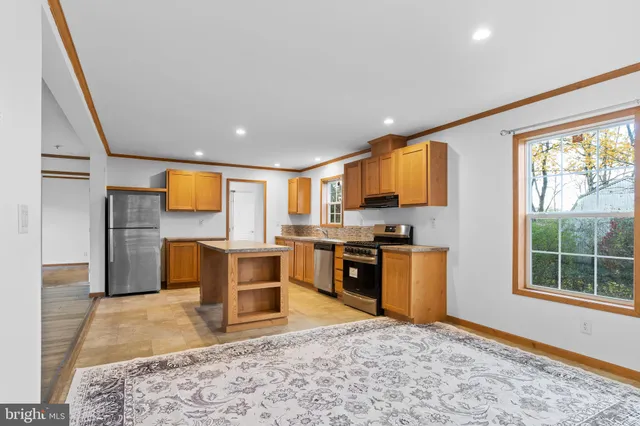 a kitchen with stainless steel appliances granite countertop a refrigerator stove top oven and sink