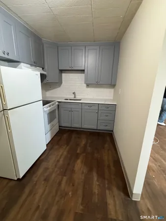 a kitchen with sink a refrigerator and cabinets