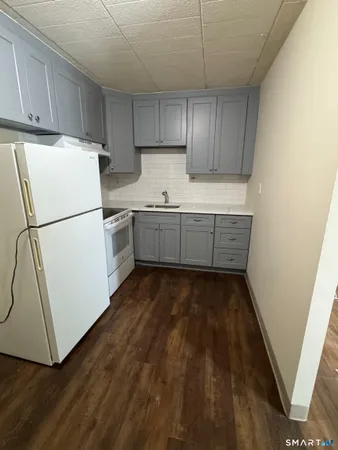 a kitchen with sink a refrigerator and cabinets