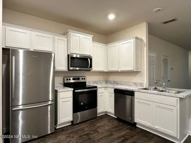 a kitchen with a refrigerator sink and microwave