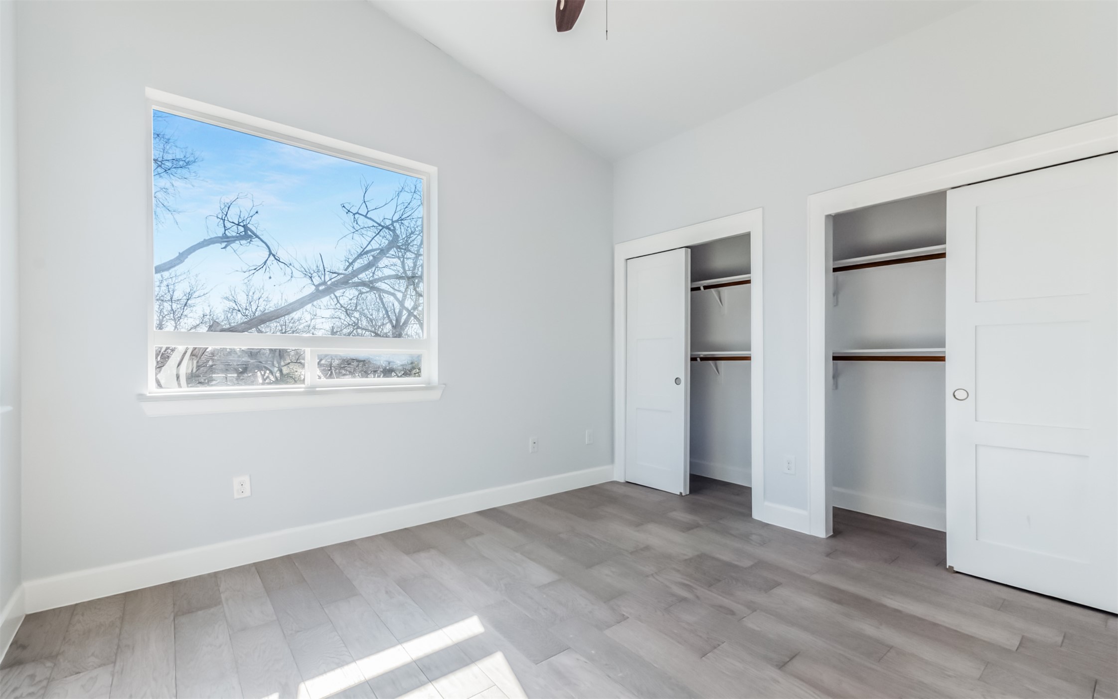 1130 Spur Street, Unit A Austin, TX 78721 - Photo 17 of 31 Unfurnished 2nd bedroom with two closets, vaulted ceiling, ceiling fan, and natural light