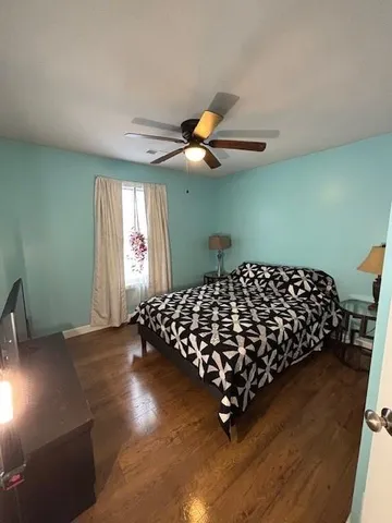 a bed sitting in a bedroom next to a window and a chandelier