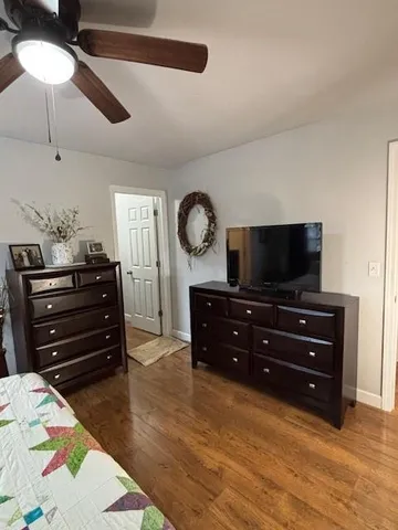 a room with a bed a flat screen tv and a dresser
